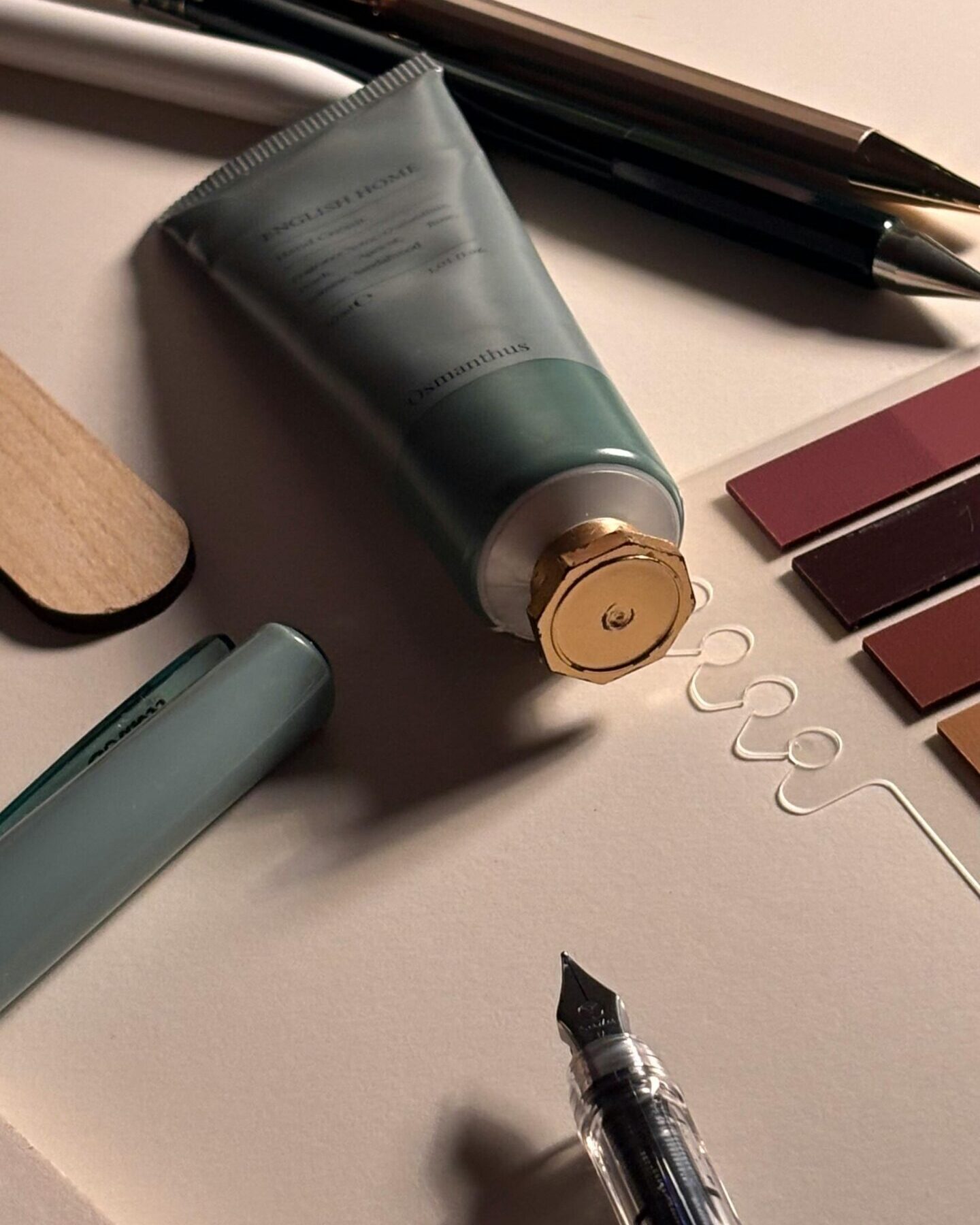 A minimalist flat lay of elegant stationery and a tube of cream, perfect for lifestyle themes.